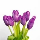 Bouquet of ten violet tulips with green leaves on a white background.