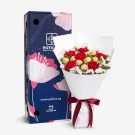 Bouquet of red carnations and white statice with Ferrero Rocher chocolates, next to a blue floral gift box.