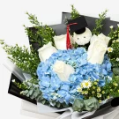 Blue hydrangea and white roses bouquet with graduation cap and teddy bear.