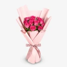 Bouquet of 12 pink roses wrapped in pale pink paper, tied with a ribbon.