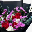 Bouquet with red and white roses, purple statice, and eucalyptus leaves.