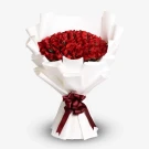 A large bouquet of 100 red roses, wrapped in white paper and tied with a burgundy ribbon.