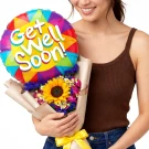 Woman holding a bouquet with a "Get Well Soon!" balloon and a sunflower.