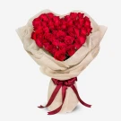 Heart-shaped bouquet of 50 red roses, wrapped in beige paper and tied with a burgundy ribbon.