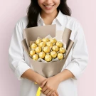 Woman holding a bouquet of Ferrero Rocher chocolates wrapped in brown paper.