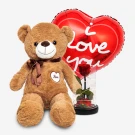 Teddy bear with a heart-shaped balloon that says "I Love You" and a preserved rose under glass.
