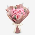 Pink spray roses and eucalyptus in a blush pink bouquet with a cream ribbon.