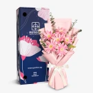 Pink gerbera daisy bouquet with pink wrapping and a decorative box with floral designs.