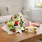 Bouquet of lilies and roses with a box of Ferrero Rocher chocolates.