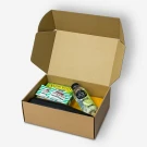 Open gift box with football plushie, tumbler, Nature Valley bars, and lime water.