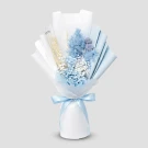 A bouquet of dried blue flowers and wheat, wrapped in white and light blue paper and tied with a blue ribbon.