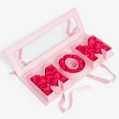 Pink box with "MOM" in cutout letters, filled with hot pink soap roses and tied with ribbon.