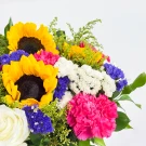 A vibrant bouquet of sunflowers, white rose, pink carnation, and assorted small flowers in purple, white, and yellow.