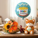 Birthday bundle: orange gerbera daisies, sunflower, fox plushie with cake, and "Happy Birthday" balloon.