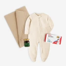 Cream onesie, swaddle, jar of chicken essence, and baby wipes.