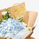 Bouquet of blue hydrangeas, white carnations, asters, and "Thank You" topper.