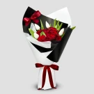 Bouquet of red roses and white tulips wrapped in black and white paper, tied with red ribbon.