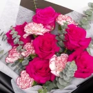 Pink roses and red-and-white carnations with eucalyptus in a bouquet.