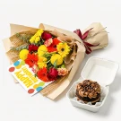 Birthday bouquet with red, yellow, and orange flowers, a birthday card, and a chocolate cupcake in a white box.