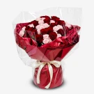 A bouquet of red and pink roses wrapped in cellophane with red paper and a cream ribbon.