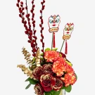 A floral arrangement with red roses, carnations, pussy willow, and lion dance figurines.