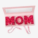 Pink soap roses spelling "MOM" in a pink gift box with a mirrored lid.
