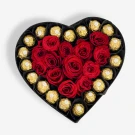 Heart-shaped box with red roses and gold-wrapped chocolates.