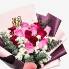 Bouquet of pink and red roses with "Best Mom Ever" topper and eucalyptus, wrapped in pink and purple paper.