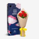 Red roses in a bouquet with a decorative box.
