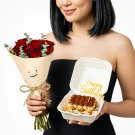 Woman holds red roses and a tiramisu cake with "Happy Birthday" decoration.
