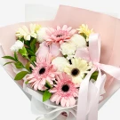 A bouquet of pink and white gerbera daisies and carnations with a pink ribbon.
