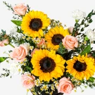 Sunflower bouquet with pink roses and white carnations in a black box.