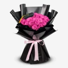 Bouquet of 50 vibrant pink roses with a graduation cap on a black wrap, tied with a pink ribbon.
