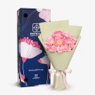 Pink gerbera and carnation bouquet with green wrapping and decorative box.