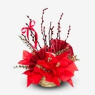 A woven basket overflowing with red tissue paper flowers, red fan decorations, and pussy willow branches.