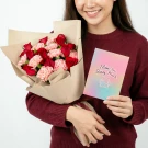 Woman holding a bouquet of red roses and pink carnations with a card that says "I love you Beary Much."