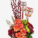 A festive floral arrangement with carnations, roses, red pussy willow branches, and lion dance decorations.
