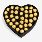 Heart-shaped box filled with gold-wrapped chocolates.