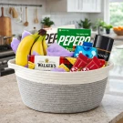 Gift basket filled with bananas, snacks, and a bottle of cologne on a kitchen counter.