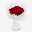 A bouquet of 30 red roses wrapped in white paper, tied with a white ribbon.