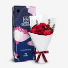 Red roses, carnations, and pom poms in a bouquet with a decorative box.