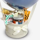 Gift basket with a balloon, candy, jar, and ribbon in a round box.