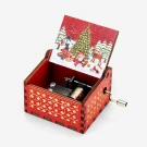 Red wooden music box with Christmas scene on lid and gold pattern on sides.
