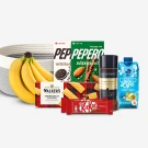 A gift hamper with bananas, cookies, coffee, KitKat, and coconut water.