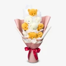 Bouquet of white chocolates and brown teddy bears tied with a pink ribbon.