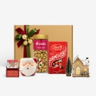 Christmas gift box with pistachios, Lindt chocolates, Santa mug, music box, and a mini tree.