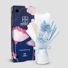 Blue dried flower bouquet with rose, hydrangea, and wheat in light blue and white wrapping, next to a dark blue box with floral design.