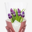 Bouquet of six unopened purple tulips with white netting, wrapped in rose gold paper.