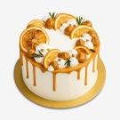 Caramel-drip cake with candied oranges, caramel balls, and white meringue swirls.