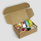 Gift box filled with chocolates, snacks, a bottle of sparkling juice, and festive candies.